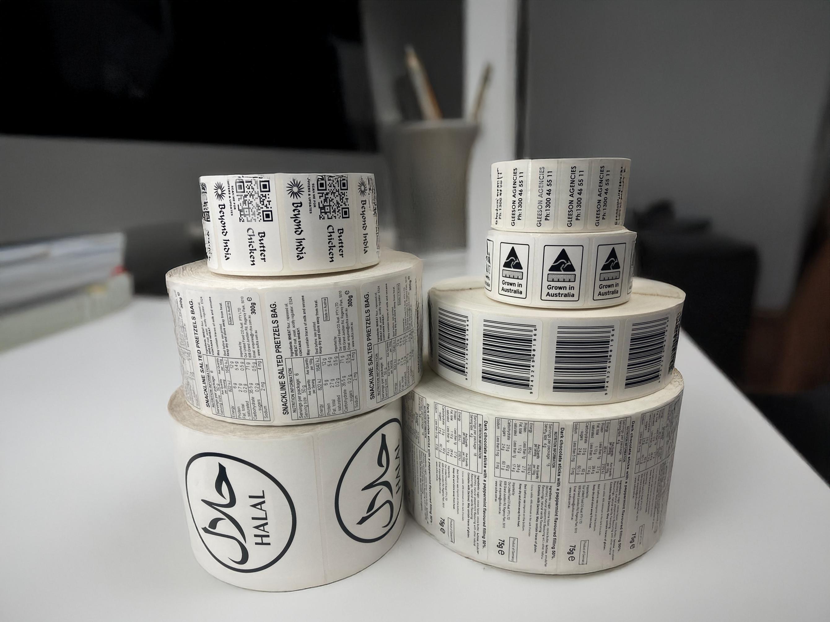Rolls of printed ingredient and food labels on a desk